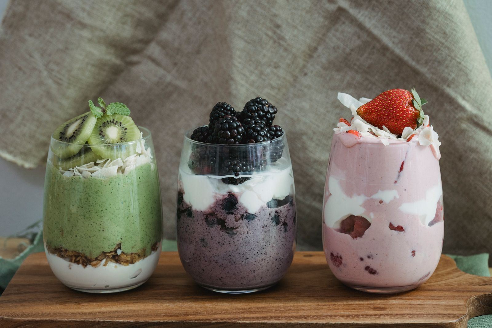 Trois verrines de smoothie et de yaourt aux fruits, des aliments faciles à manger avec un appareil